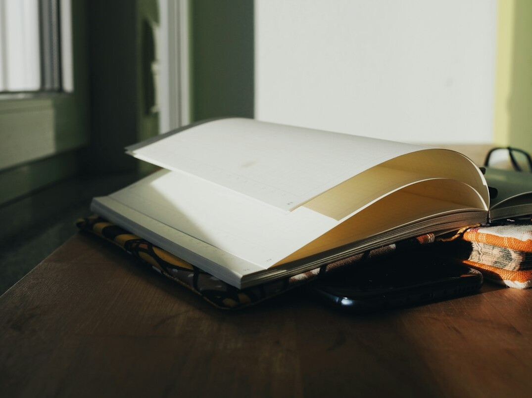 Stack of books with an open notebook on top